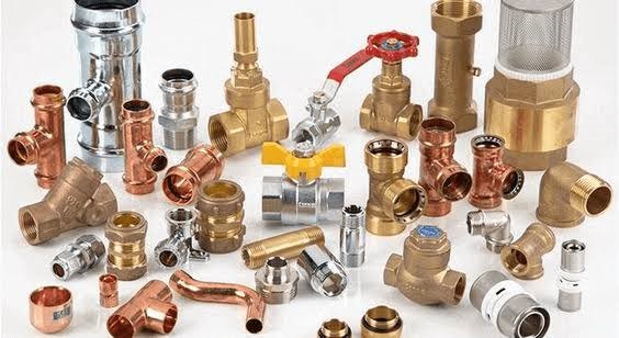Collection of brass and copper plumbing fittings, valves, connectors, and pipe joints arranged on a white background.
